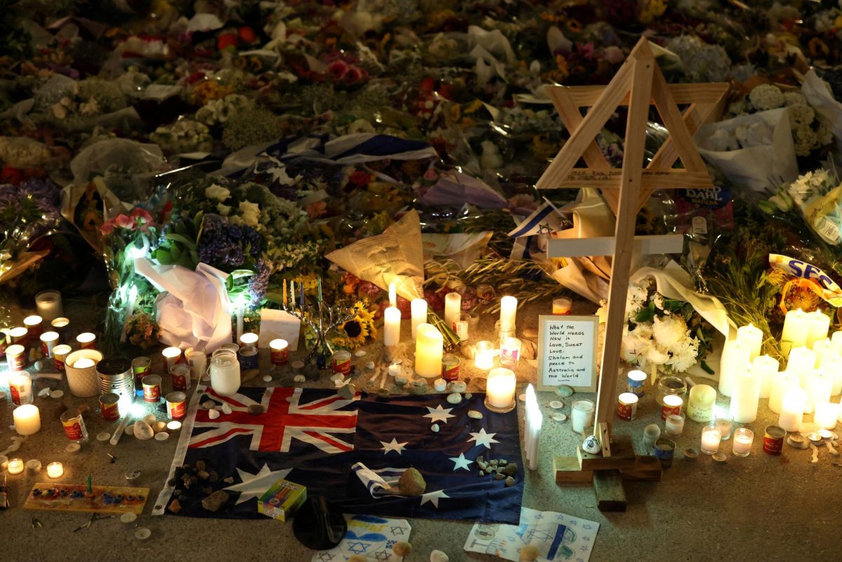 An Australian flag sits amongst floral tributes honouring the victims of a shooting at Jewish holiday celebration at Bondi Beach, in Sydney, Australia, December 16, 2025. REUTERS/Hollie Adams