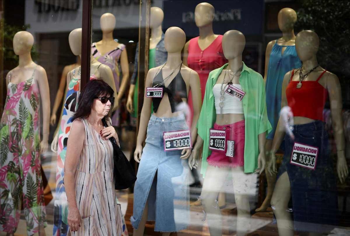 A woman walks past a clothing store, as Argentina is battling with an annual inflation heading towards 200%, in Buenos Aires, Argentina January 4, 2024. REUTERS/Agustin Marcarian