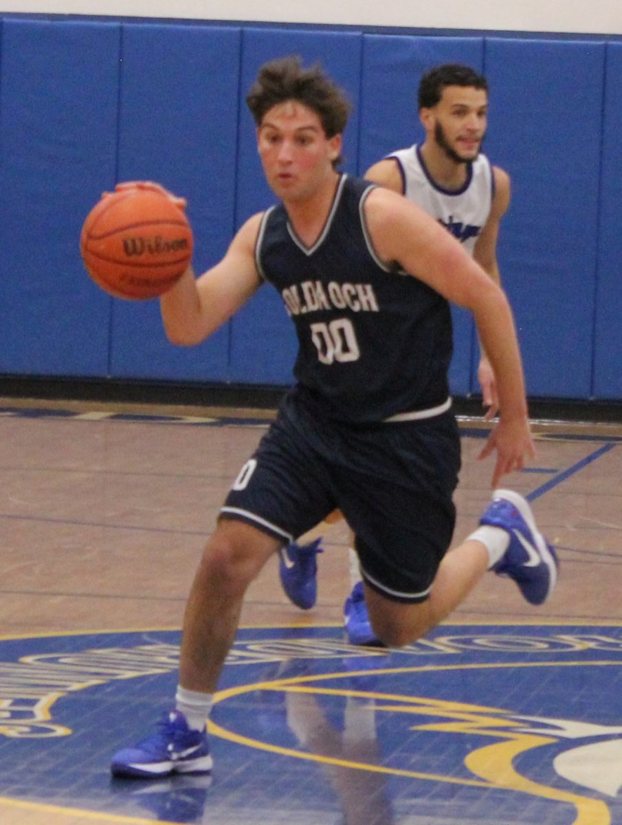 Caleb Lustig '26 dribbles past opponents on Sandy Pyonin Court at the GOA Upper School.