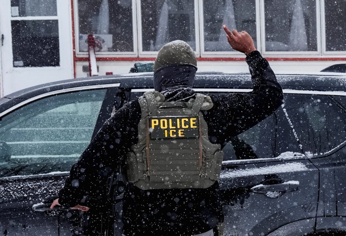An Immigration and Customs Enforcement (ICE) agent raises a finger moments after detaining a man during an immigration raid, in Minneapolis, Minnesota, U.S., January 18, 2026. REUTERS/Leah Millis