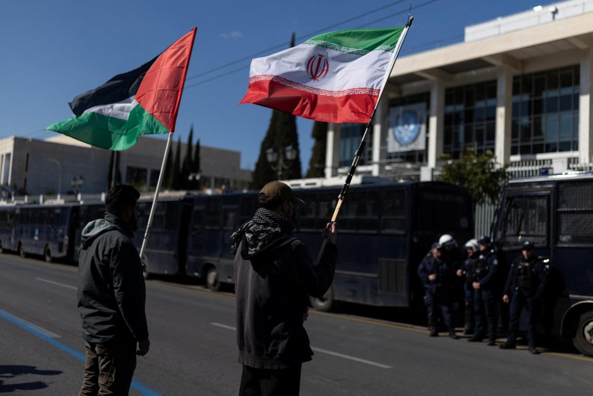 Protesters hold Palestinian and Iranian flags during an anti-war demonstration outside the U.S. Embassy. REUTERS/Stelios Misinas