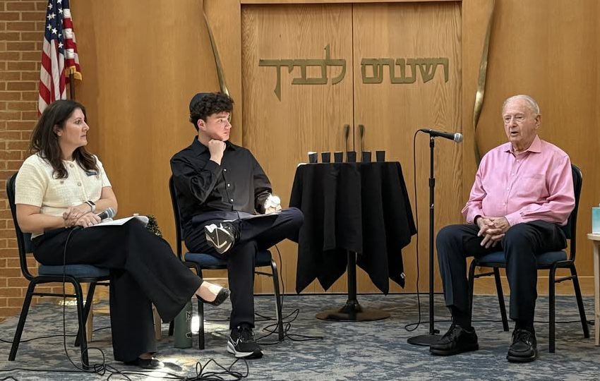 Mrs. Sternthal, Associate Director of Marketing and Leo De Picciotto '28 interview Holocaust survivor Norbert in front of the entire Upper School